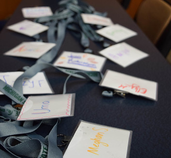 Photo of a gray table with colored name tags strewn on it.